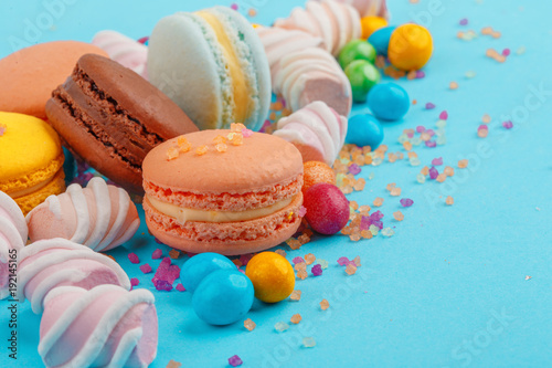Macarons and sweets on a colored background. Festive mood