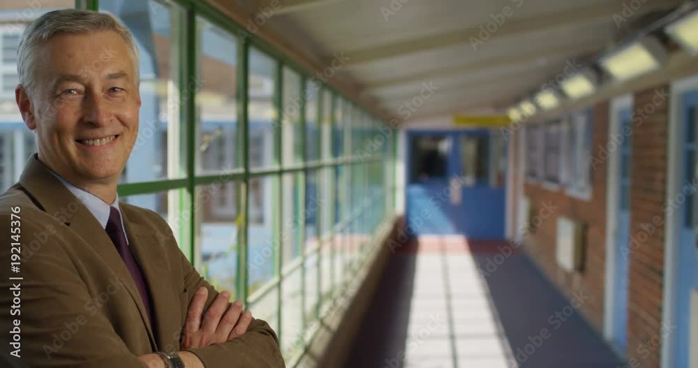4K Portrait smiling friendly teacher standing in school hallway on a sunny day. Slow motion 4K Portrait smiling friendly teacher standing in school hallway on a sunny day. Slow motion