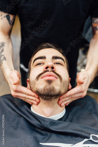 Barber master prepares face of client for shaving