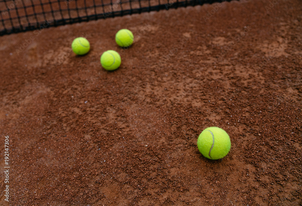 Close up view of tennis yellow balls on the clay tennis court. Sport and recreation concept.