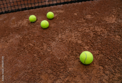 Close up view of tennis yellow balls on the clay tennis court. Sport and recreation concept. © Maksym Azovtsev