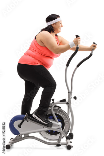 Overweight woman exercising on a cross-trainer machine
