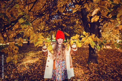 beautiful young girl in autumn park smiling
