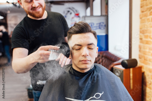 man is getting hairstyle at barber shop