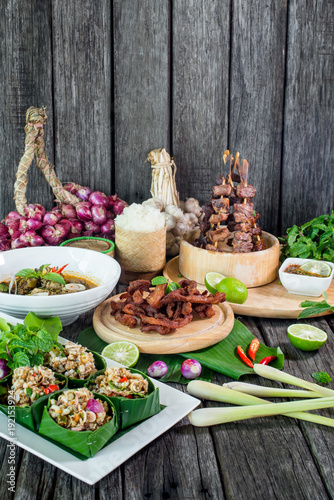 Spicy Raw Ant Eggs Salad, Oxtail soup, grilled ox tongue, deep fried beef on the table with herbs