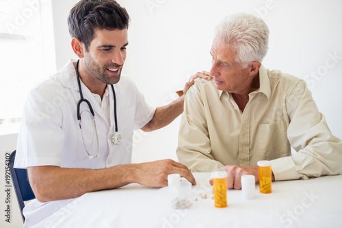 Nurse giving medicine to senior man photo