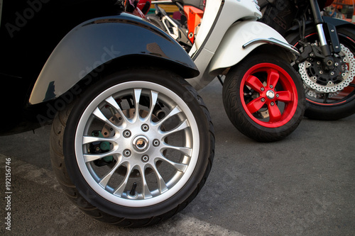 New motorcycles standing in the row closeup on wheels © PRASERT