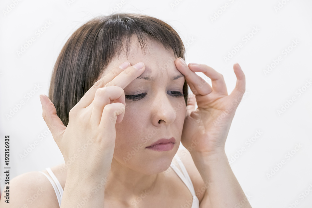 A young woman checking wrinkles on her forehead. Horrified young woman looking in the bathroom mirror staring open mouthed a first sign of ageing A young woman checking wrinkles on her forehead. Horrified young woman looking in the bathroom mirror staring open mouthed a first sign of ageing
