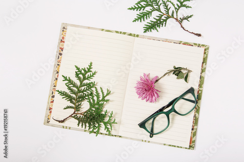notebook,glasses and flower.flat lay.white background.