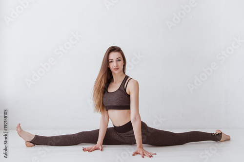 girl on a twine in a white studio. Young female, practicing yoga. Lifestyle. photo