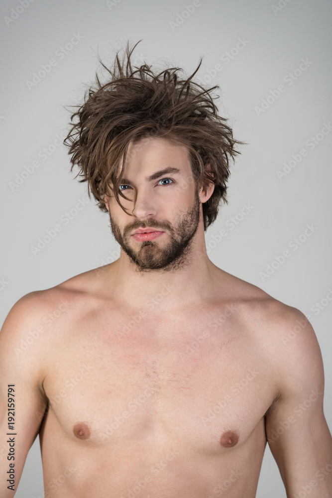 Sleepy man with beard on grey background.