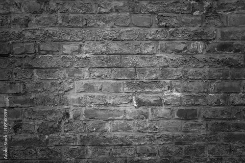 Old brick wall as background, texture or pattern. Dark wall. Poster or cover. Black and white brick wall.