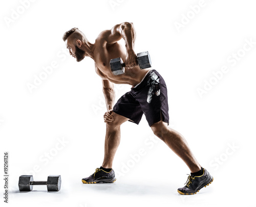 Athletic man doing exercise for arms. Photo of muscular fitness model working out with dumbbells on white background.