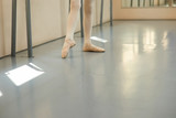 Legs of young ballerina, cropped image. Young ballet-dancer at ballet hall. Classical ballet studio.