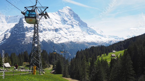 View of cable car to Grindelwald First with Alps mountains in the background, Grindelwald, Switzerland May 2017 photo