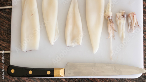 Cleaning squid, with a knife in a cooking table, cutting board