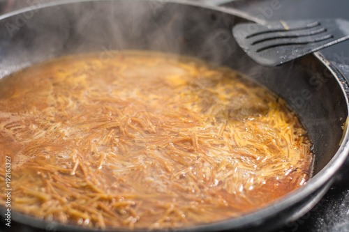 cooking a spanish fideua, a typical noodles casserole with seafood, making traditional Fideua from Spain, a typical noodle paella