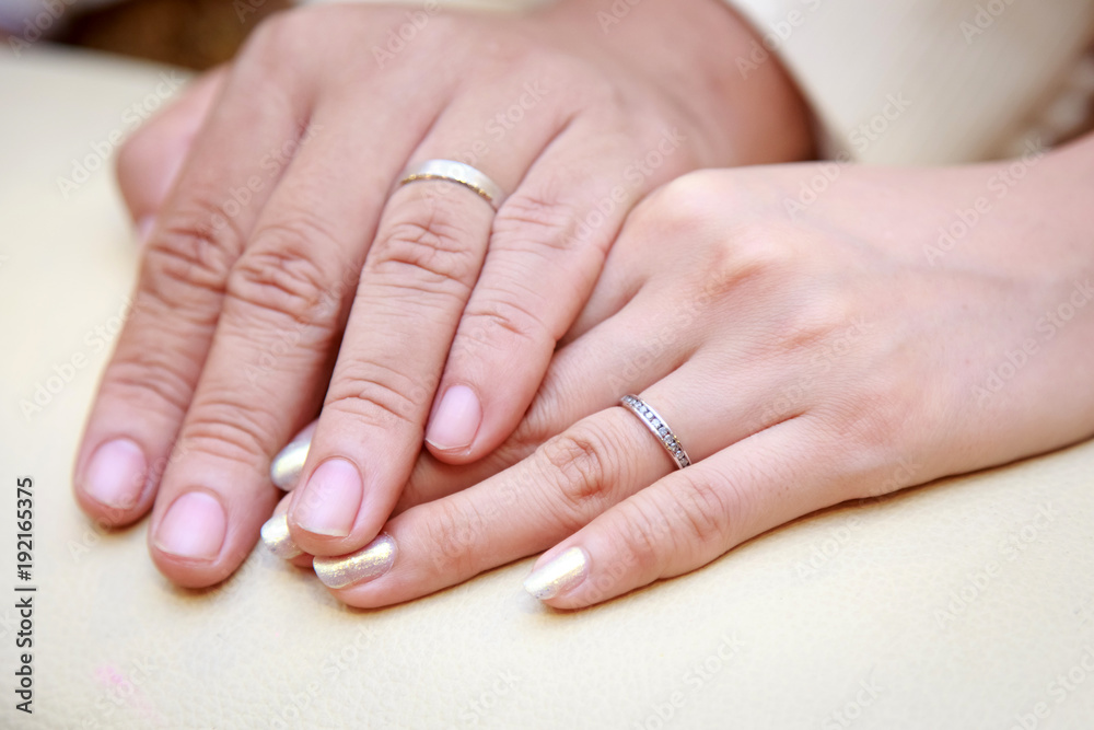 Closeup image of man and woman hands with wedding ring holding tenderly.