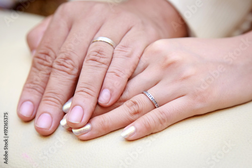 Closeup image of man and woman hands with wedding ring holding tenderly.
