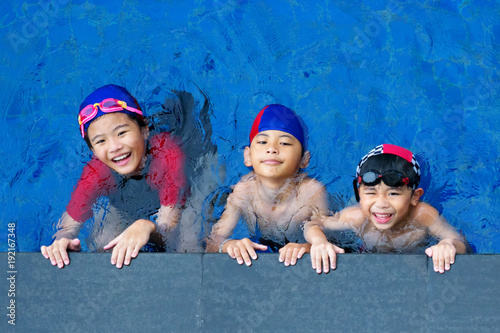 Happy children in the swimming pool. Funny kids playing outdoors. Summer vacation concept