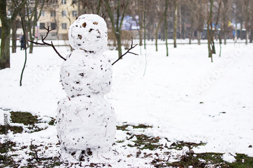 snowman with pieces of dirt and leaves photo