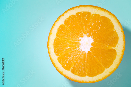 sliced orange fruit isolated on blue blackground  pop art color concept