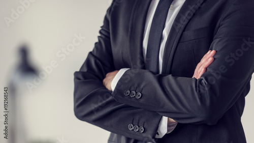Foto Torso of a businessman standing with folded arms