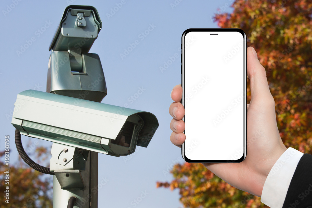 Hand with phone on background of surveillance camera. White screen  Stock-Foto | Adobe Stock