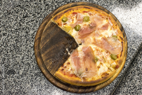 Pizza with prosciutto and mozzarella on a cutting board