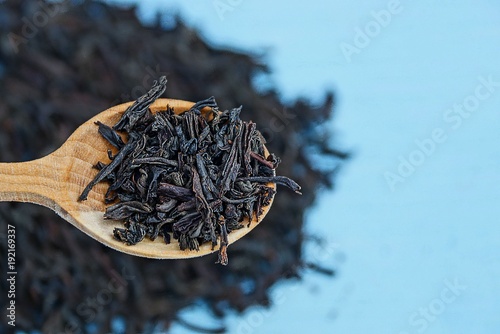 чёрный сухой чай в деревянной коричневой ложке