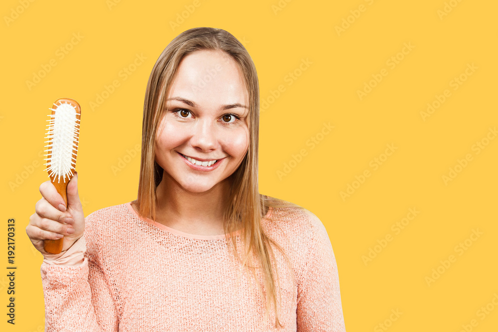 Portrait of a beautiful smiling young woman holding comb, isolated. Portrait of a beautiful smiling young woman holding comb, isolated.
