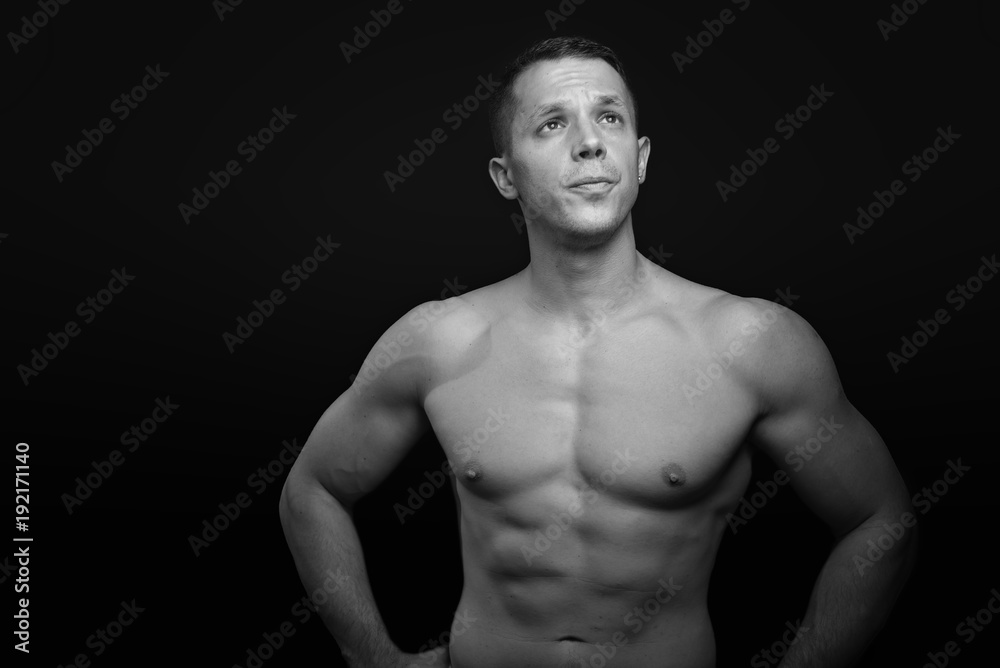 Portrait of a shirtless athletic guy, black background Portrait of a shirtless athletic guy, black background