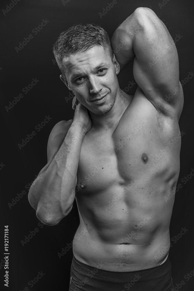 Portrait of a shirtless athletic guy, black background Portrait of a shirtless athletic guy, black background
