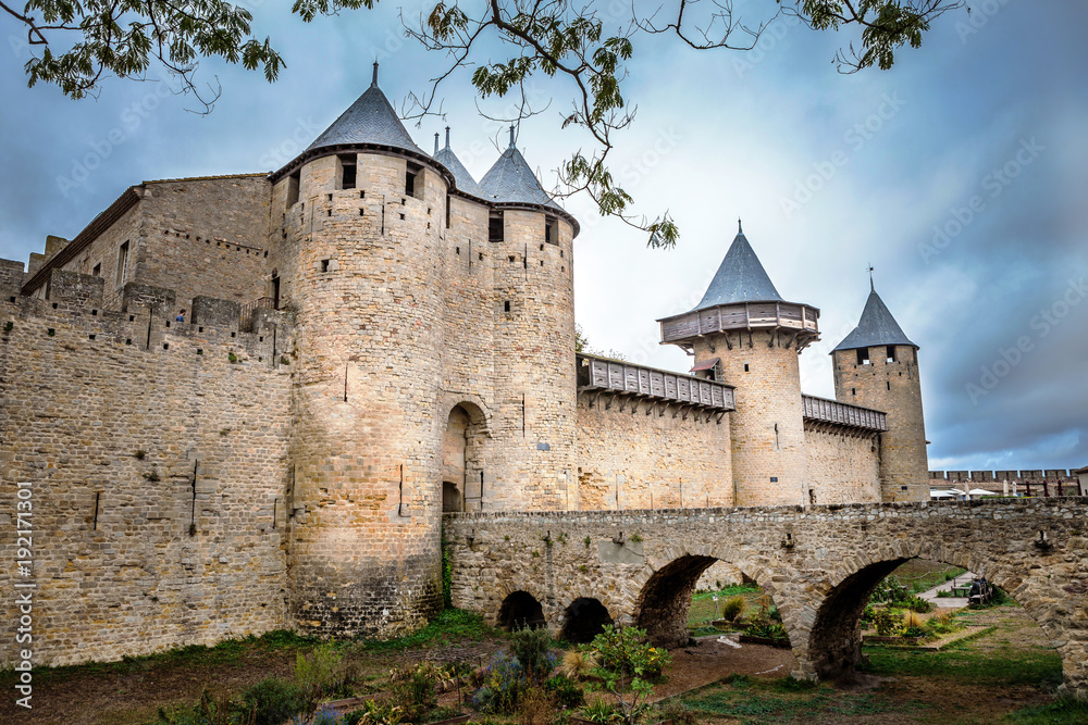 Castle walls of Carcassonne fortress in France with crowd clouds on the background