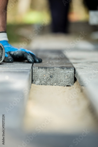 Manual worker installing paving block