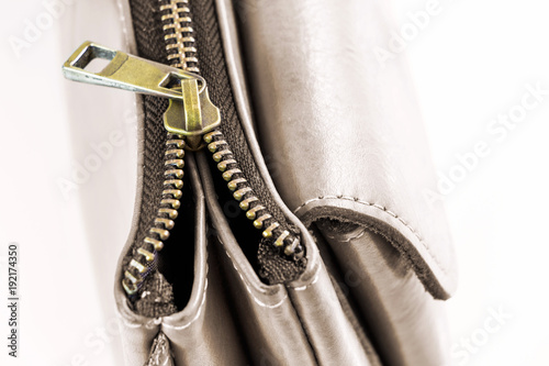 Golden brass zipper on a leather bag. selective focus.