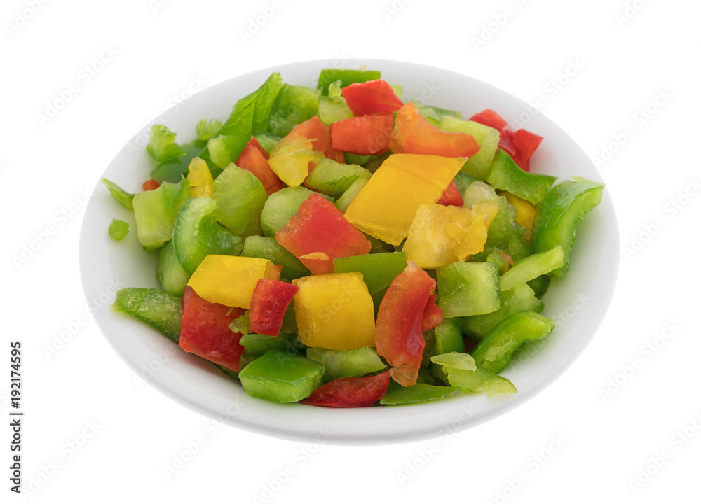 A portion of chopped red, yellow and green bell peppers in a small bowl isolated on a white background. A portion of chopped red, yellow and green bell peppers in a small bowl isolated on a white background.