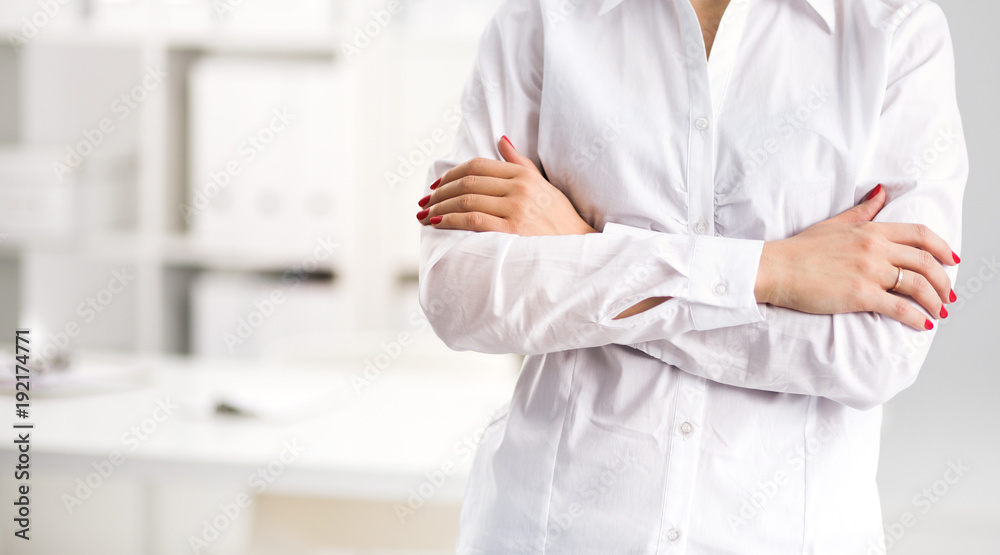 Young businesswoman standing with her arms crossed isolated on a white background Young businesswoman standing with her arms crossed isolated on a white background