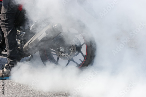 sport motorbike wheel drifting and smoking on track, background for display a text or product.