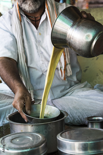 Thandai (Popular cold drink made of cardamom,saffron, almonds fennel seeds and milk ) vendor preparing and mixing thandai for customers