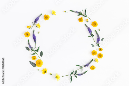 Flowers composition. Wreath made of yellow, purple flowers and eucalyptus branches on white background. Flat lay, top view, copy space