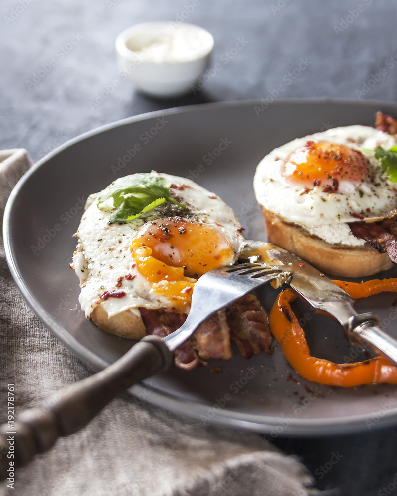 A healthy Breakfast with whole wheat toasts and Poached egg with green salad, bacon and pepper. Rustic style on dark background. Vertical. A healthy Breakfast with whole wheat toasts and Poached egg with green salad, bacon and pepper. Rustic style on dark background. Vertical.