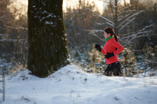 Image of sports girl on run through winter forest