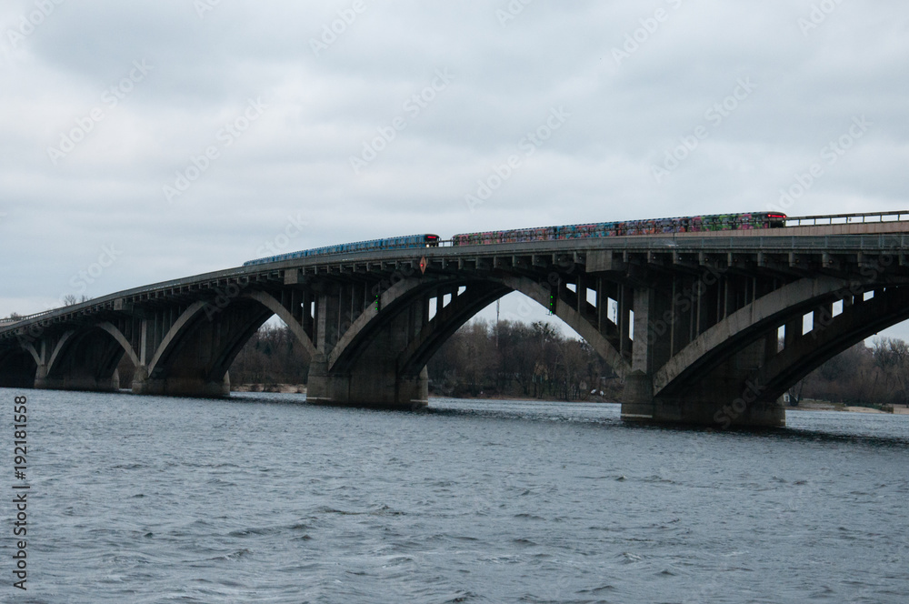 Bridge metro across the Dnieper River in Kiev. The metro train rides the bridge. Concept solutions to transportation problems Bridge metro across the Dnieper River in Kiev. The metro train rides the bridge. Concept solutions to transportation problems