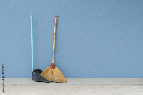 Broom with scoop of blue on blue wall © CHOKCHAI