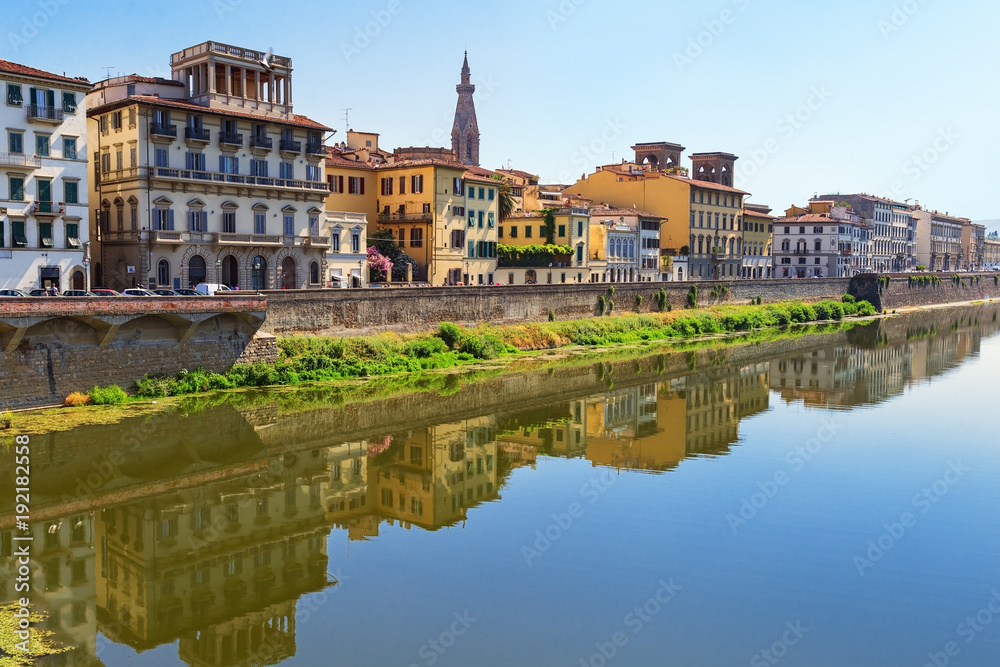 Buildings on the banks of the Arno River in the city of Florence. Italian architecture. Urban landscape in Italy. Reflections on water. June 2017.