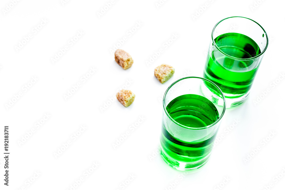 Absinthe shots near sugar cubes on white background top view copy space Absinthe shots near sugar cubes on white background top view copy space