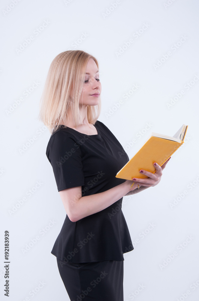 Business woman in black dress holds the yellow book in hands and looking in book.. Isolated on white background. Сoncept of responsibility and professional Business woman in black dress holds the yellow book in hands and looking in book.. Isolated on white background. Сoncept of responsibility and professional