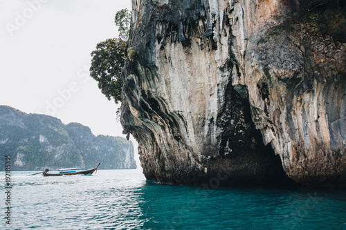 boat floating near cliff at Krabi, Thailand