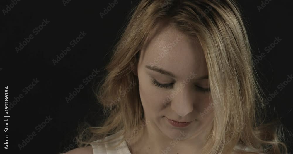 Beautiful blond woman blowing gold glitter confetti slow motion.